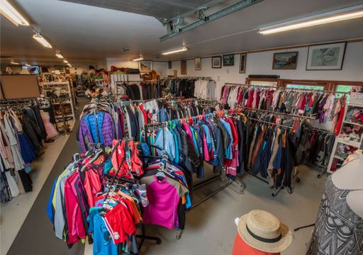 Diverse fargerike klær som er til salgs i gjenbruksbutikken 