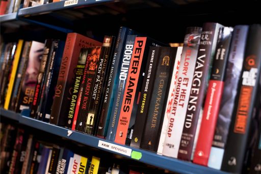 Bøker i en bokhylle som er til salg i gjenbruksbutikken